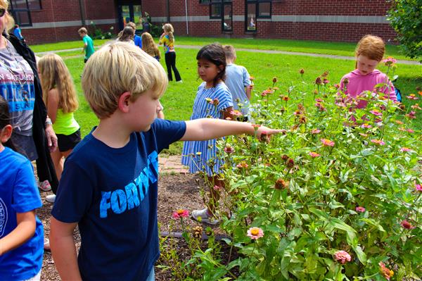 students in a flower garden with butterflies